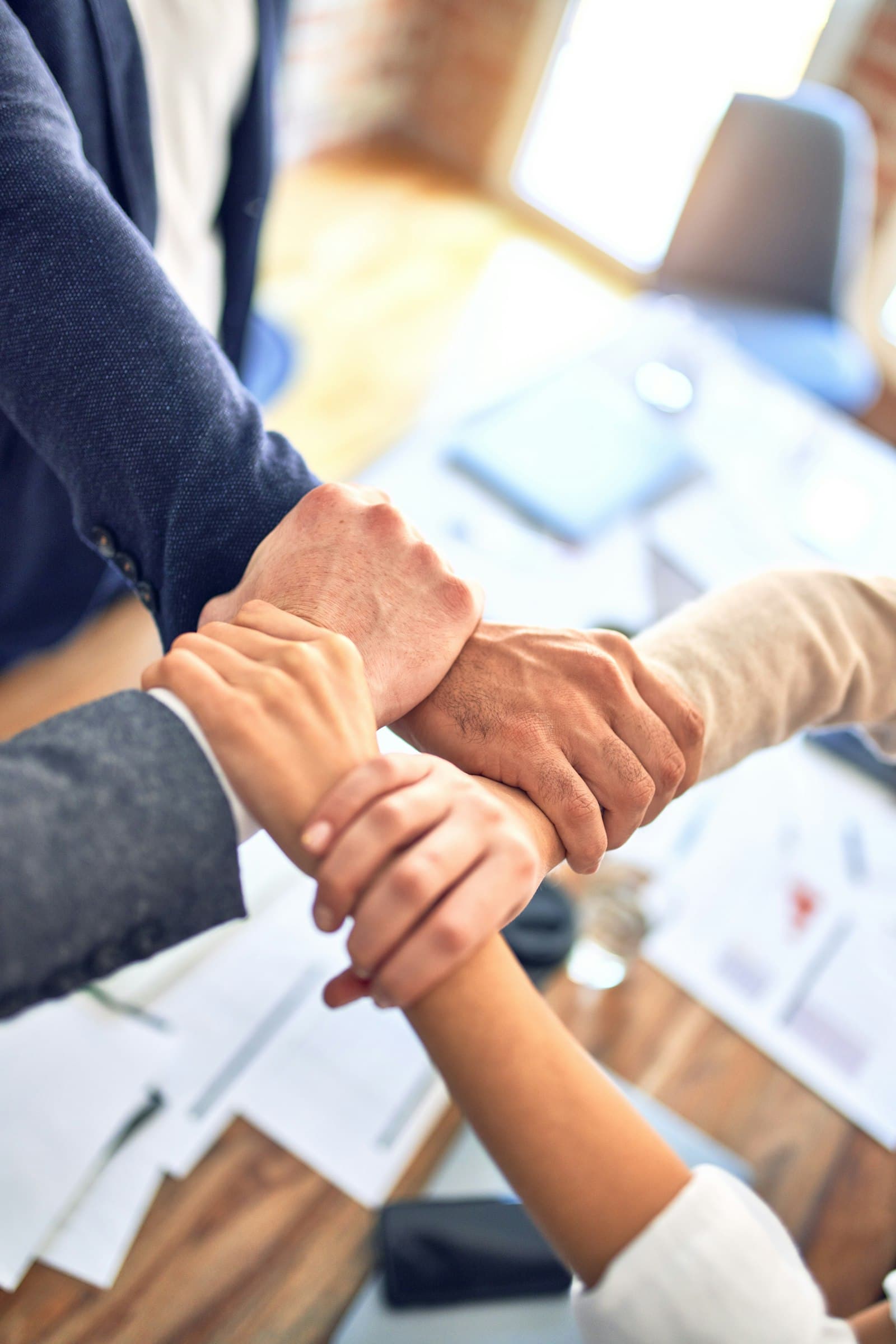 A group joins their hands together at the center, a gesture of shared commitment