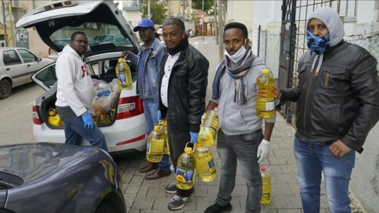 African Students Organization members loading and distributing food aid to their community.