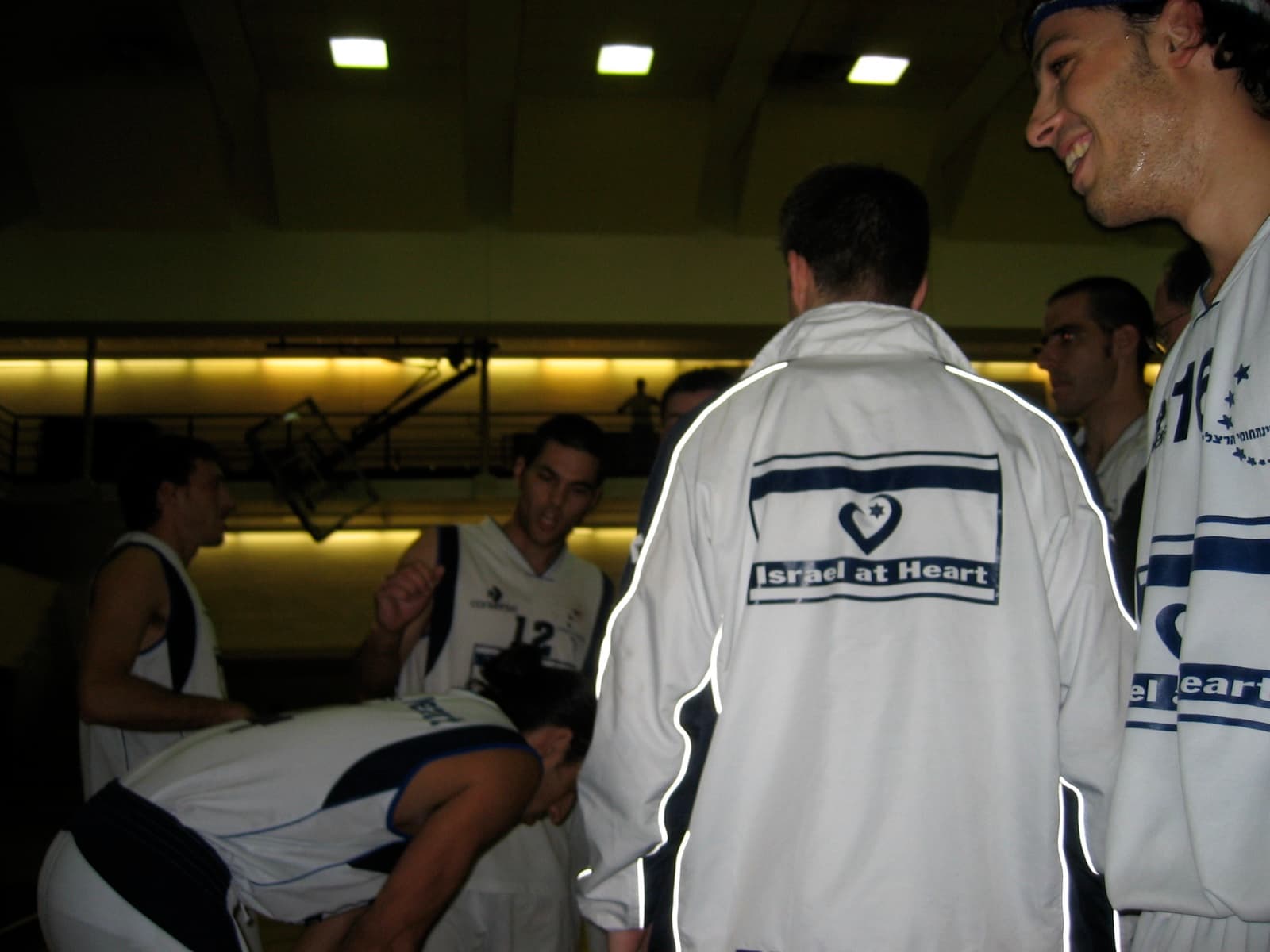 Players in Israel at Heart warm-up jackets, the team crest on the back.