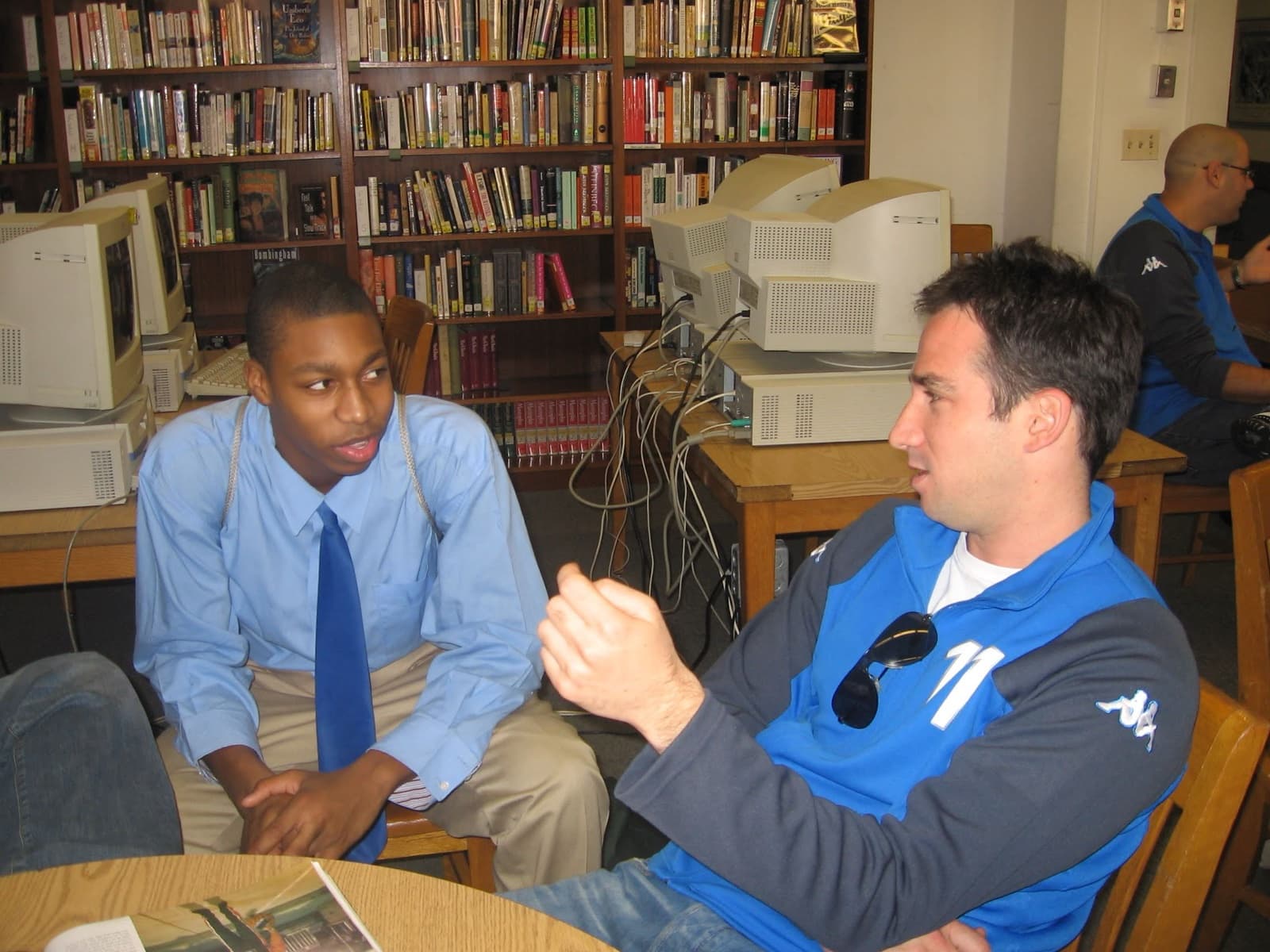 An Israeli player and an American student talking one on one in a school library.