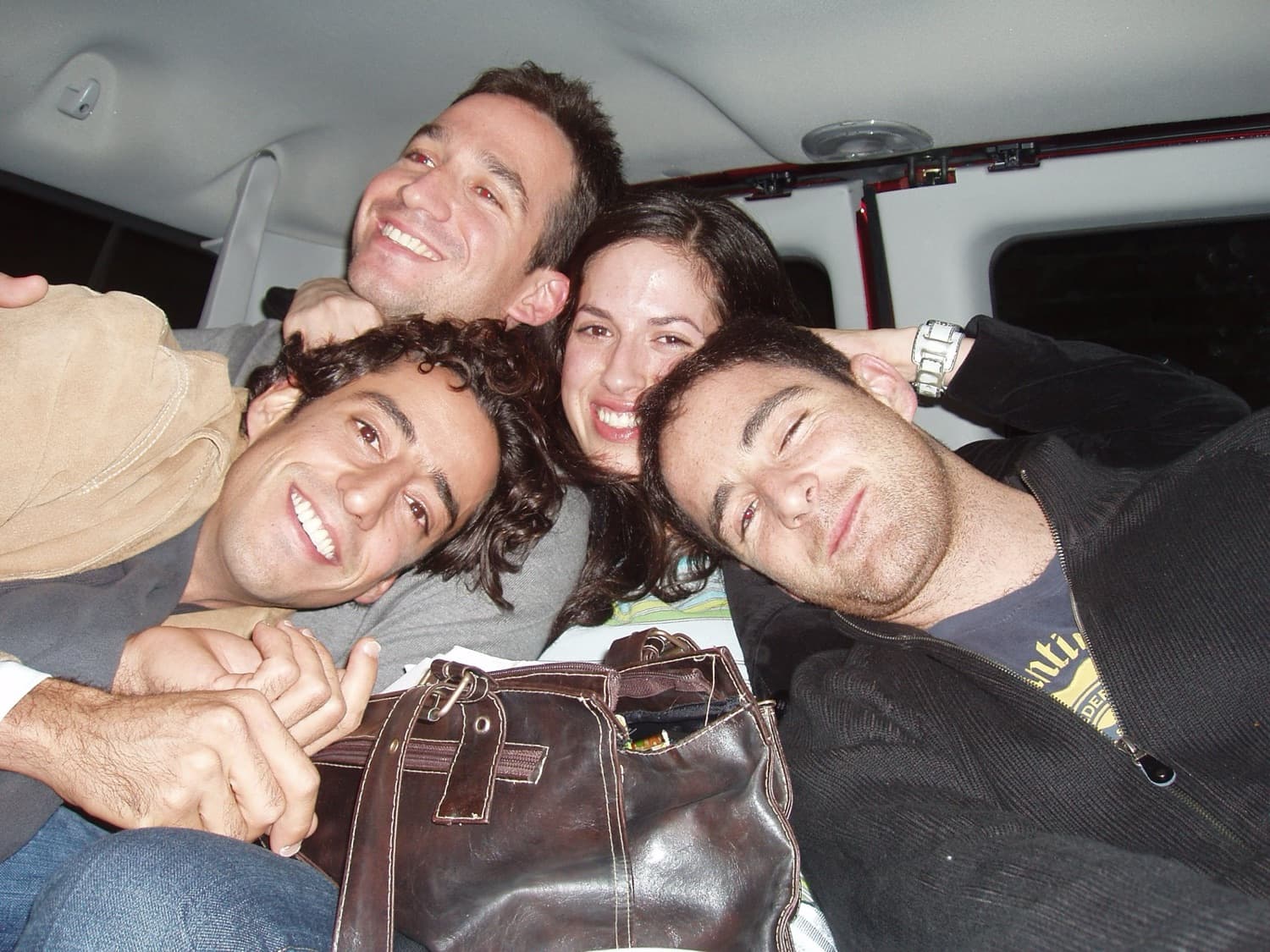Four members of the delegation squeezed together and smiling in a van.