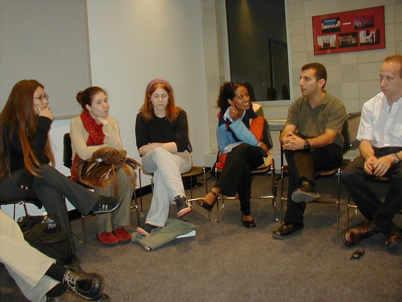Young people seated in a circle in conversation.