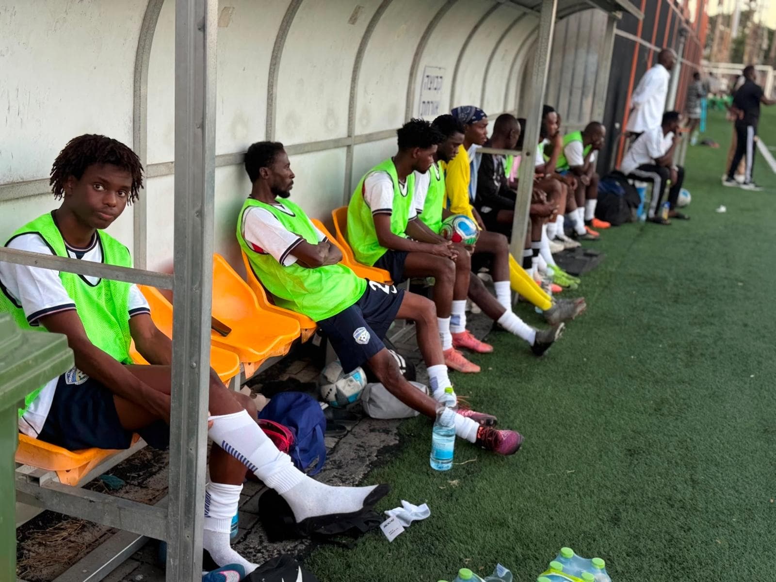 Players waiting on the bench in their kits during a match.