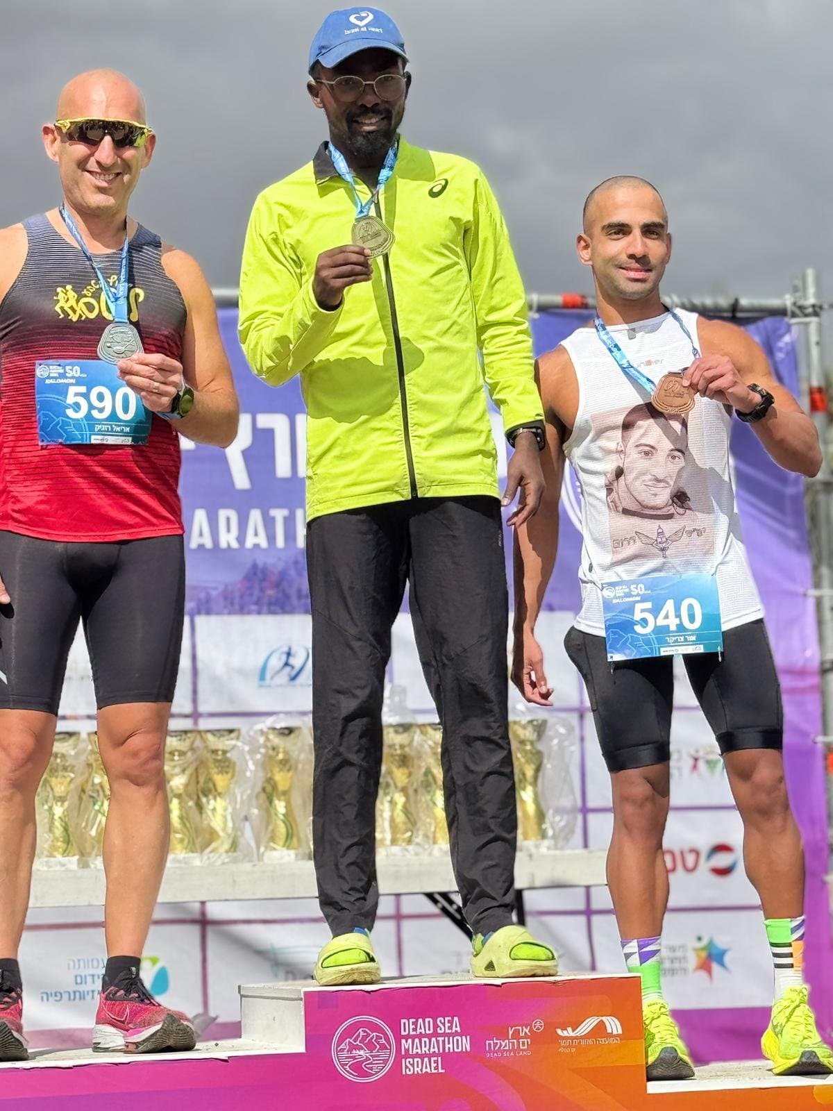 Athletes on the podium with medals at the Dead Sea Marathon.