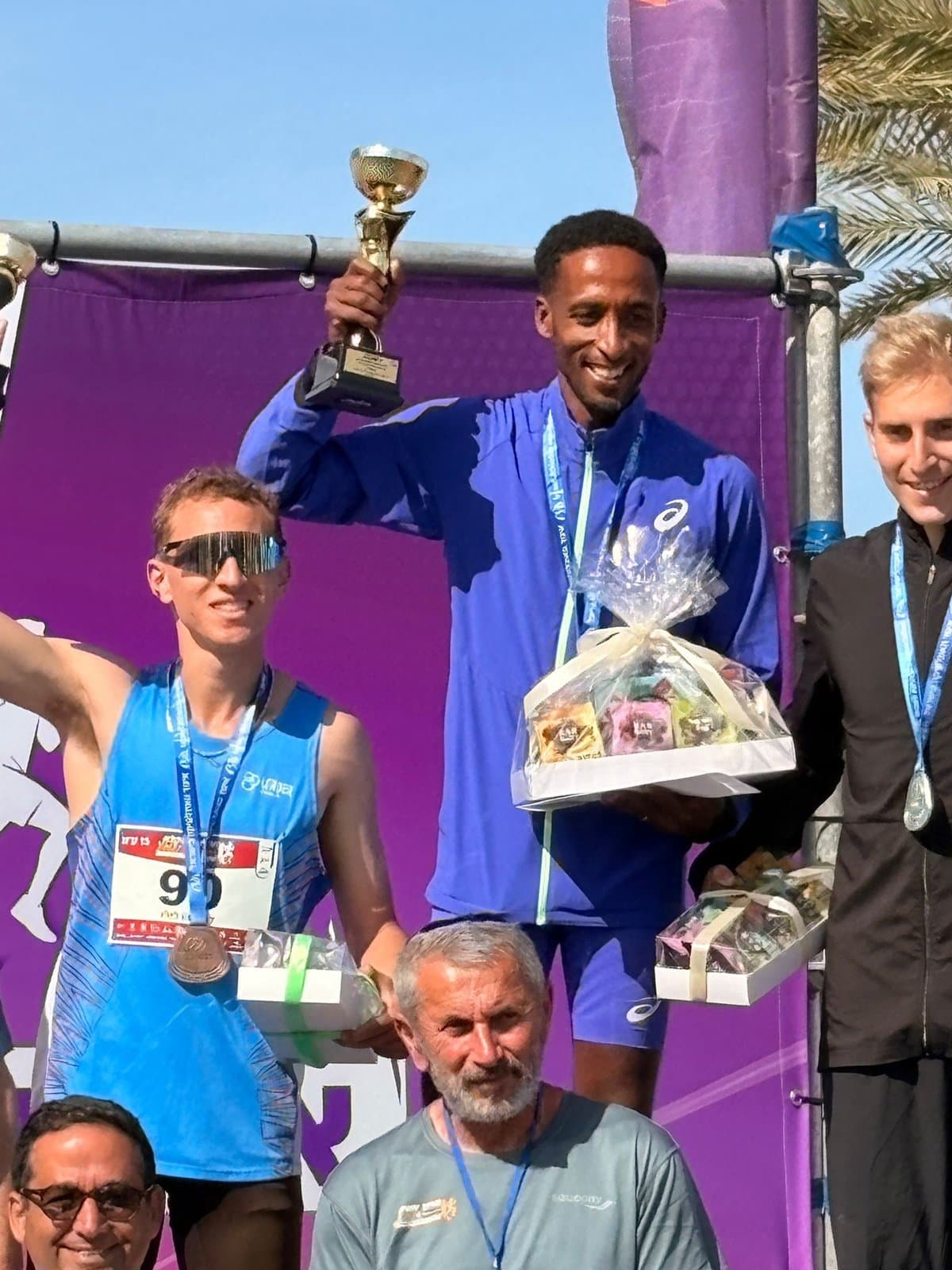 A runner on the podium with a trophy at a European championship.