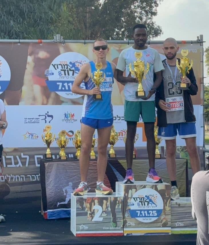 Runners on a race podium holding trophies.