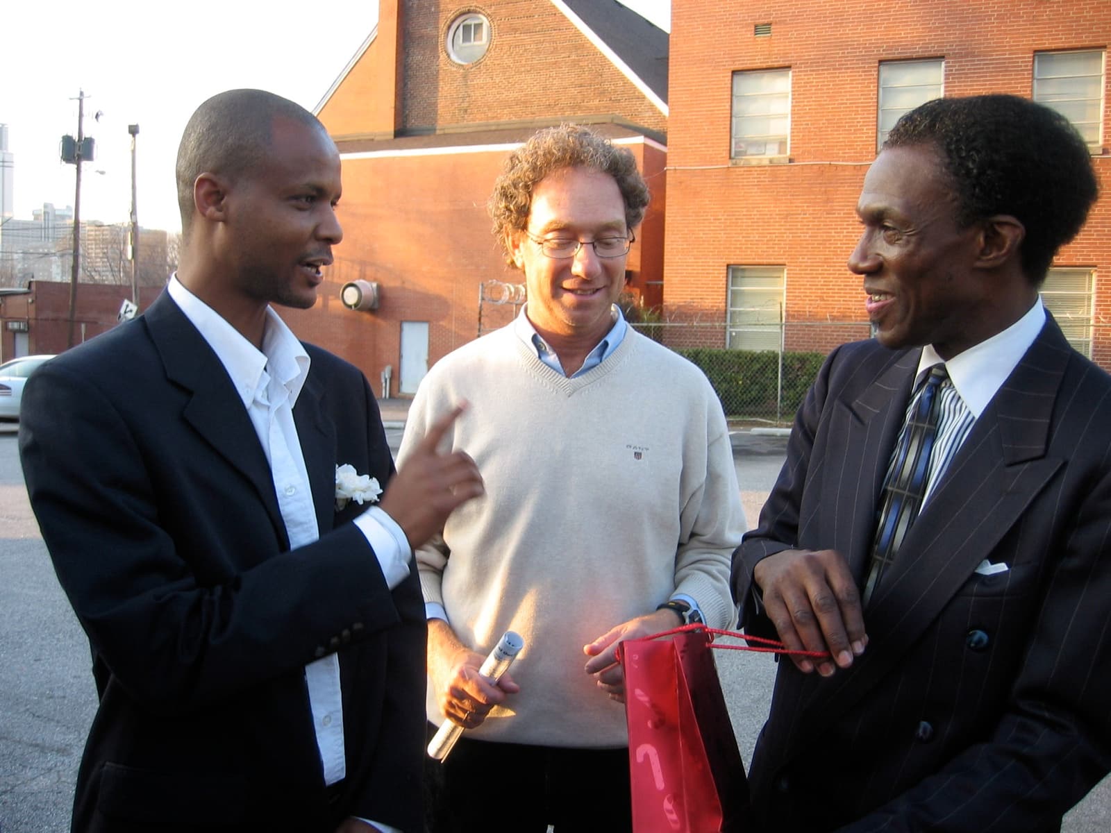An Ethiopian-Israeli delegate and Joey Low in conversation with an African American host outside a church.