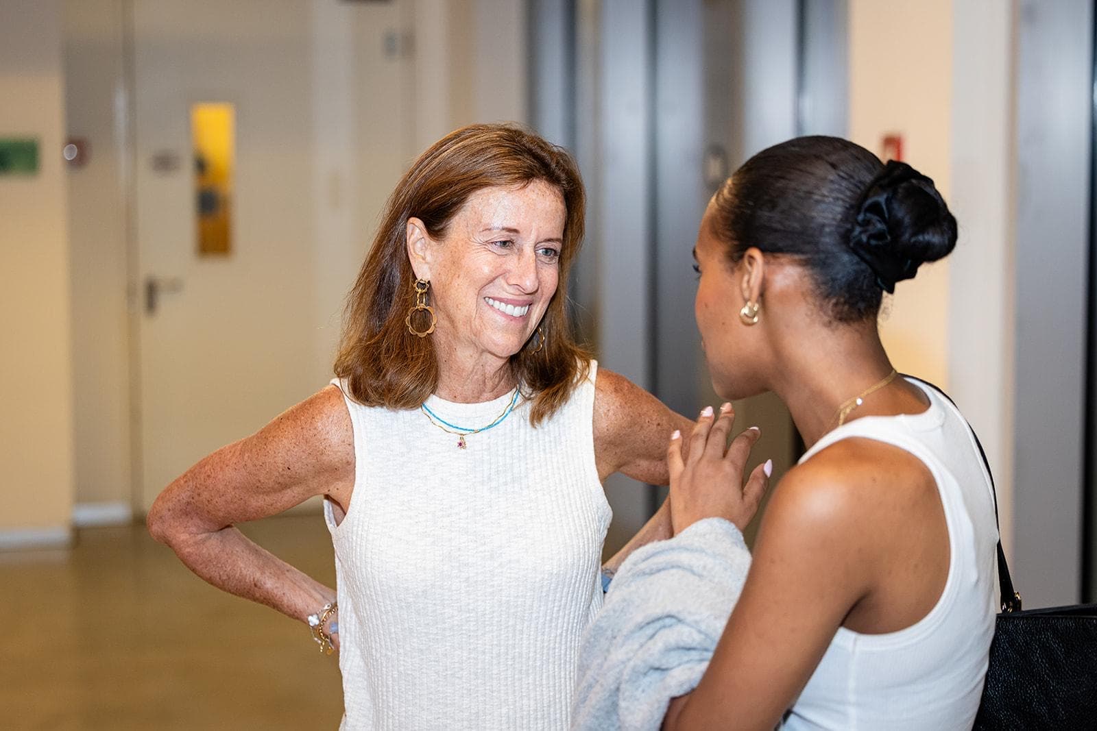 Carol Low smiling in conversation with a graduate of the program.