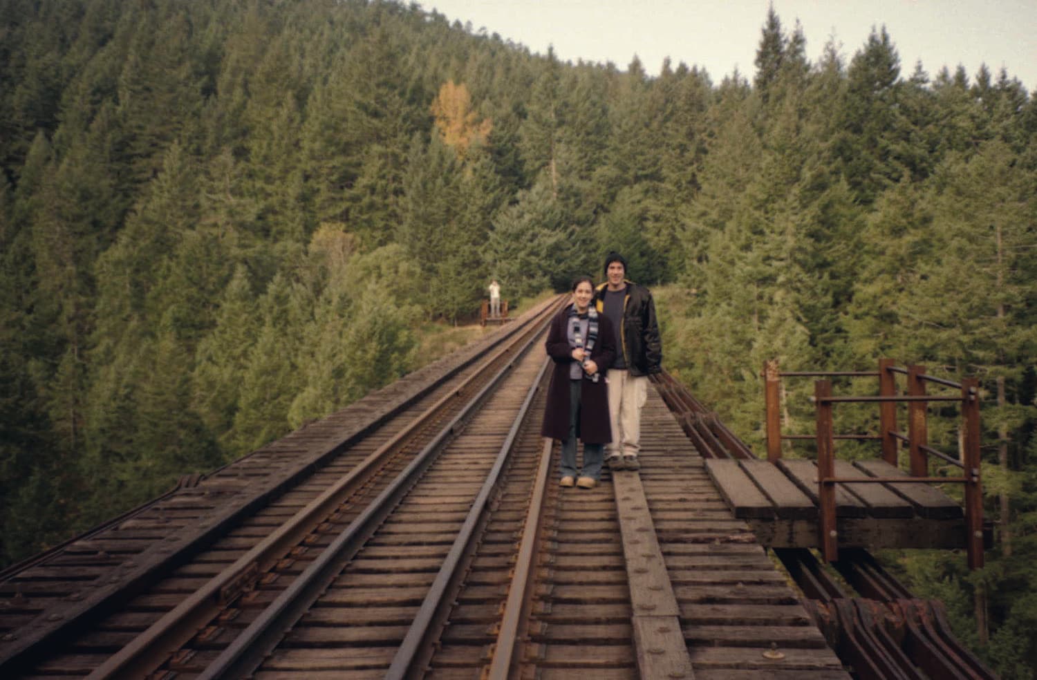 Two delegates on a railway trestle in a forest during a European trip.