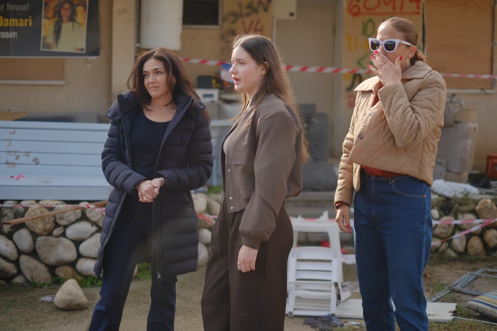 Sheryl Sandberg with Agam and Chen Goldstein-Almog outside a damaged home.