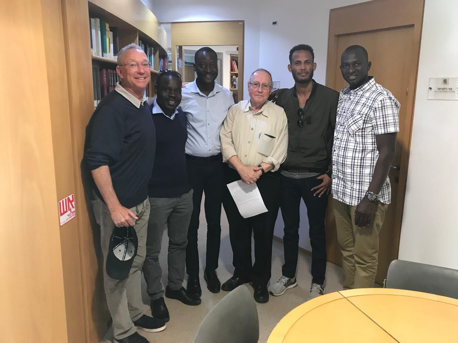 Joey Low and former Supreme Court Justice Professor Elyakim Rubinstein with members of the African refugee community.