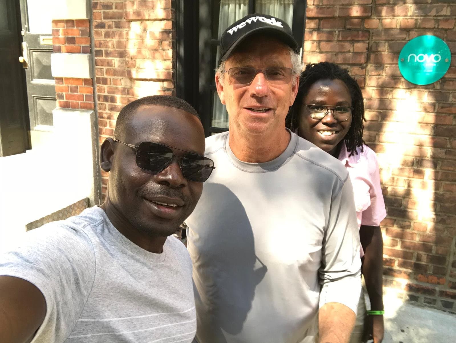 Two members of the community with Joey Low, close together and smiling.